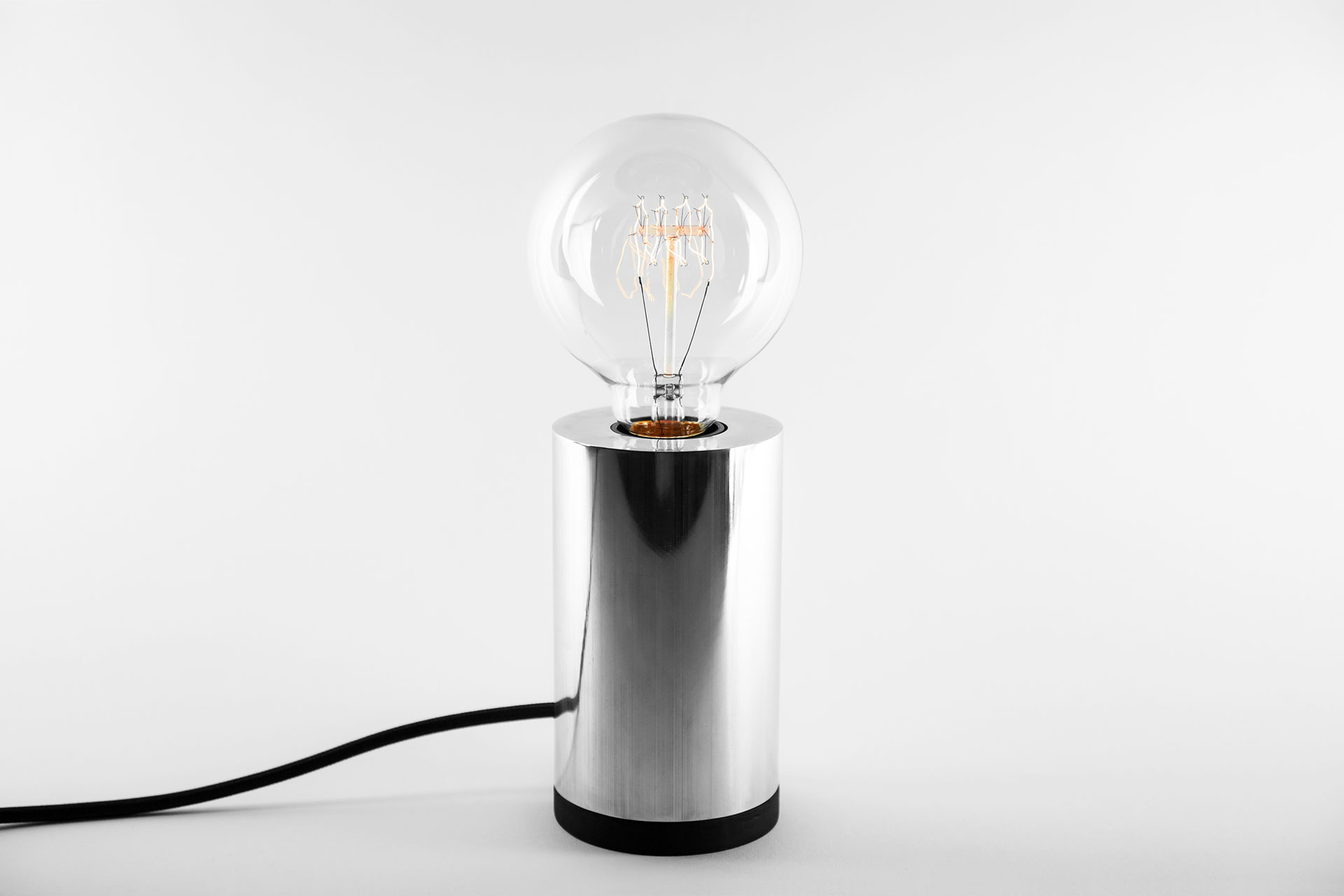 Aluminum table lamp with retro Tesla bulb inspired by masculine minimalist design