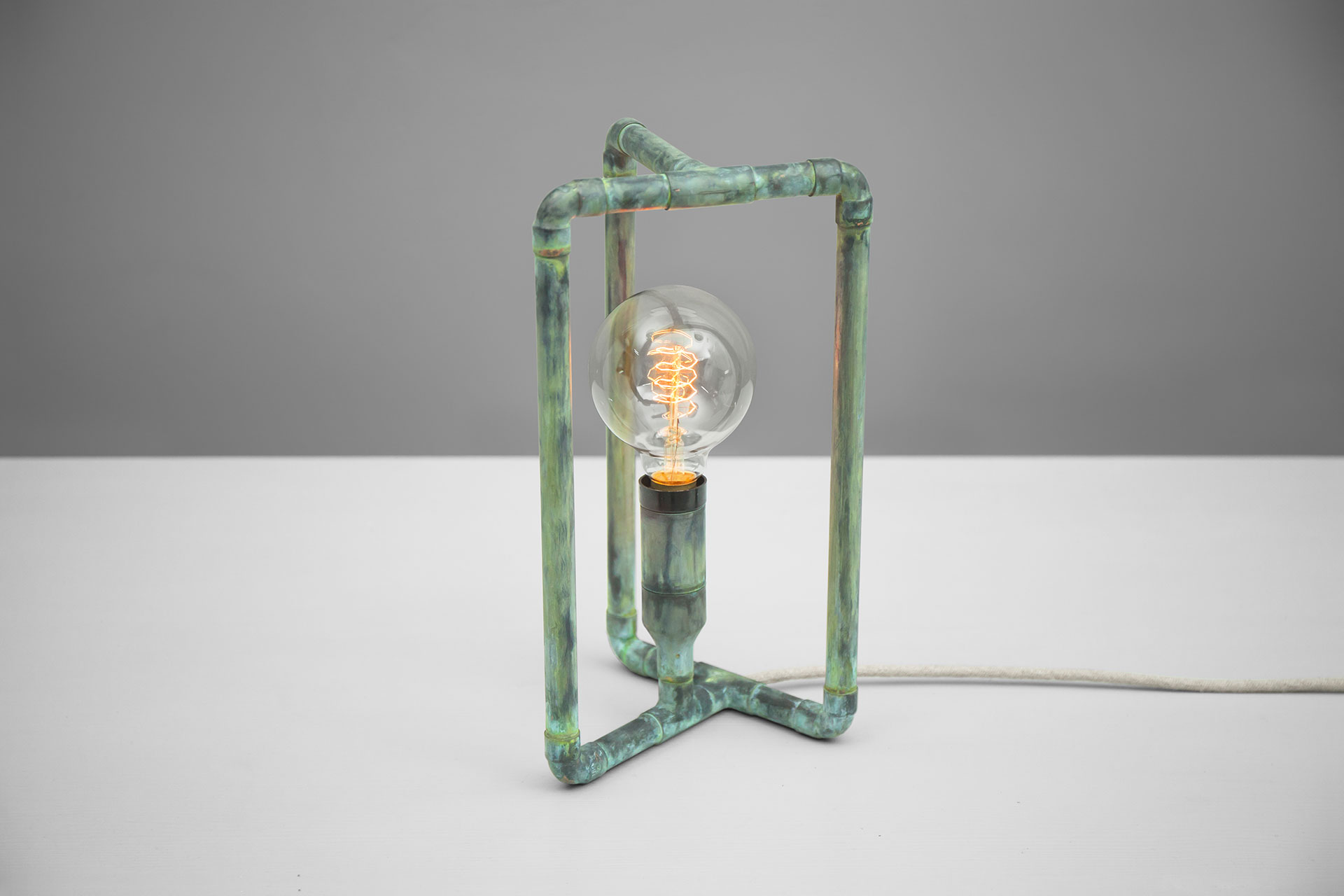 Conceptual design table lamp in handmade green patina metal finish with creative touch dimmer and retro bulb