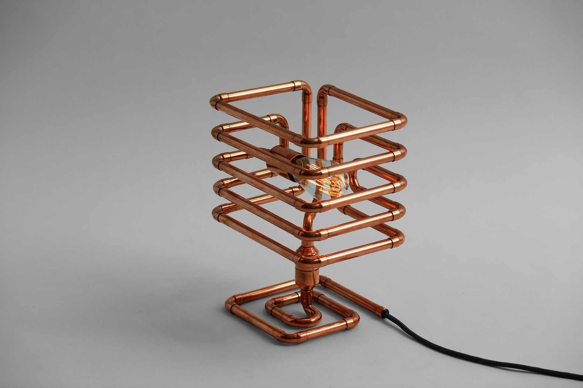 Industrial cage table lamp made of copper pipes with Tesla bulb inspired by steampunk design