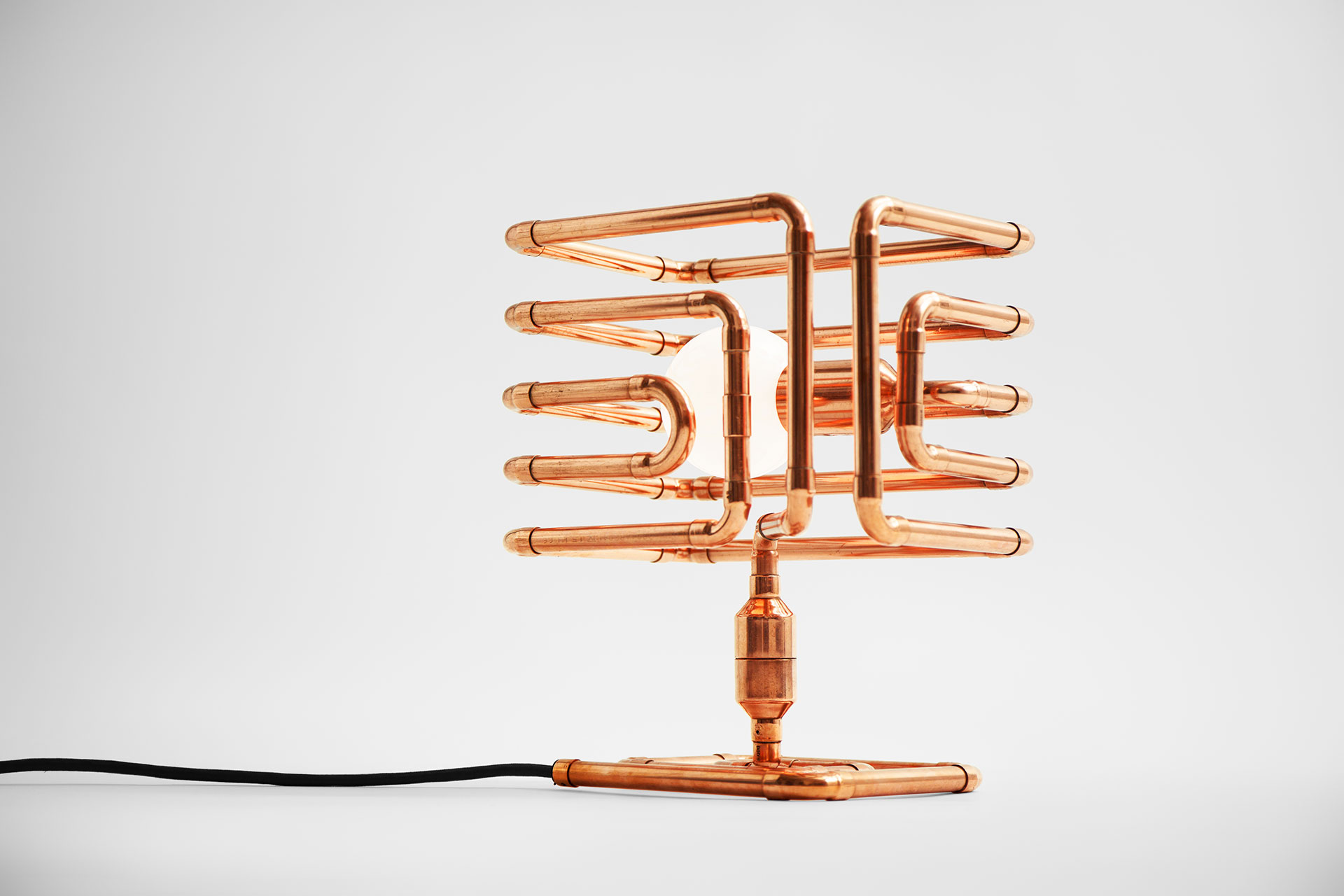 Futuristic design table lamp in trendy copper metal finish inspired by conceptual pipe art