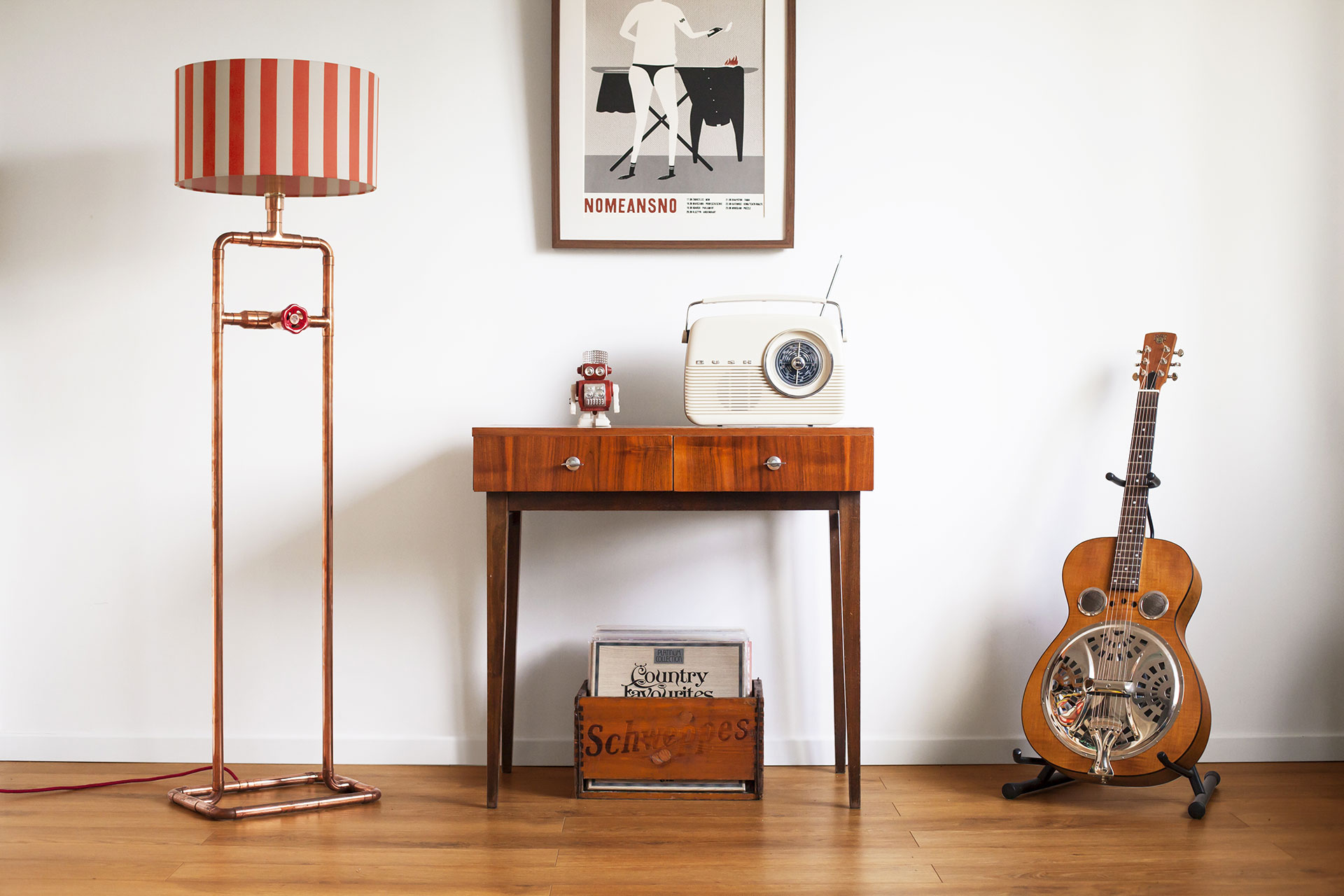 Industrial style copper tubing floor lamp with knob dimmer and stripe shade in cozy hip apartment