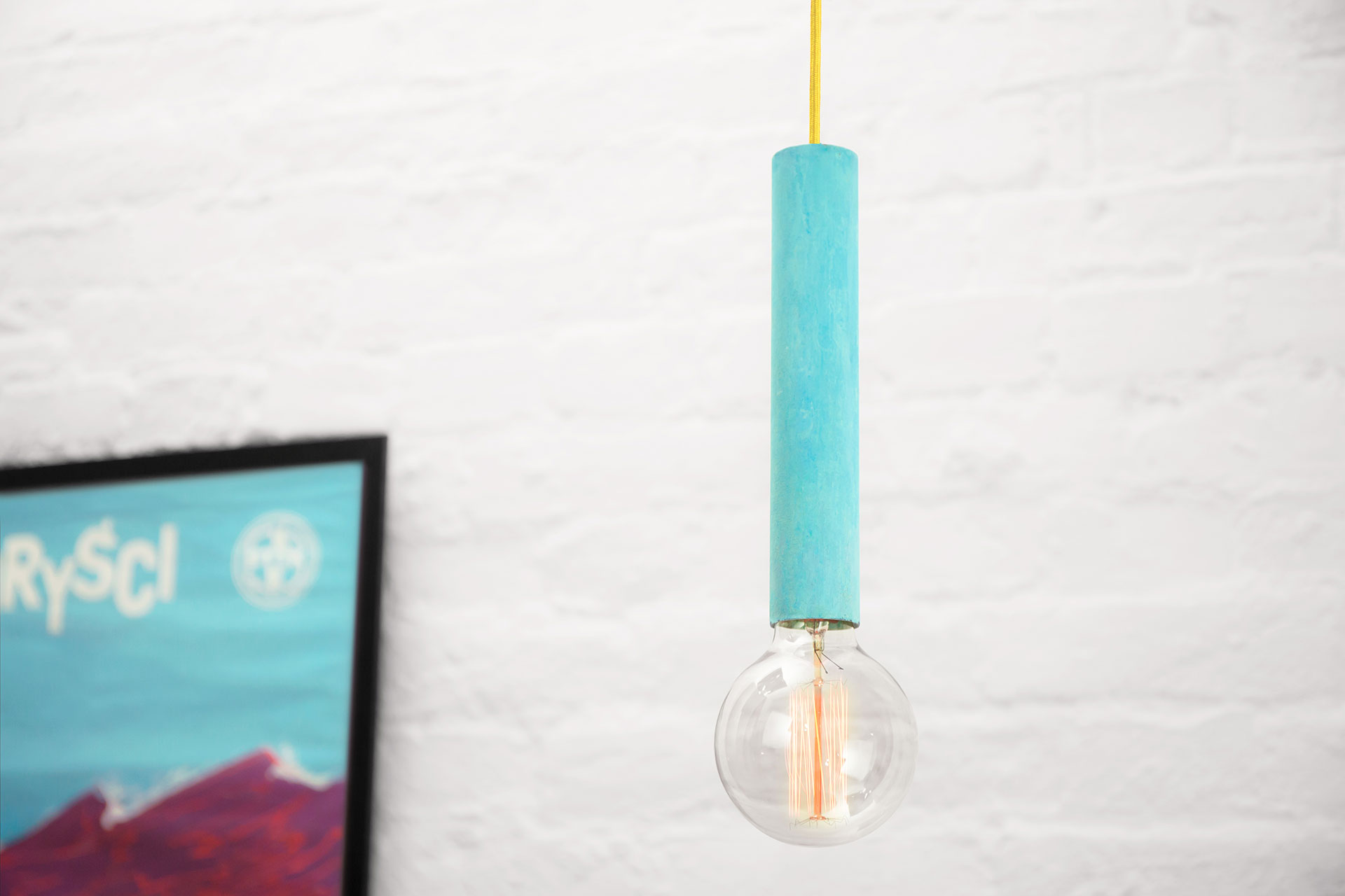 Trendy turquoise pendant lamp with yellow cord in cozy kitchen