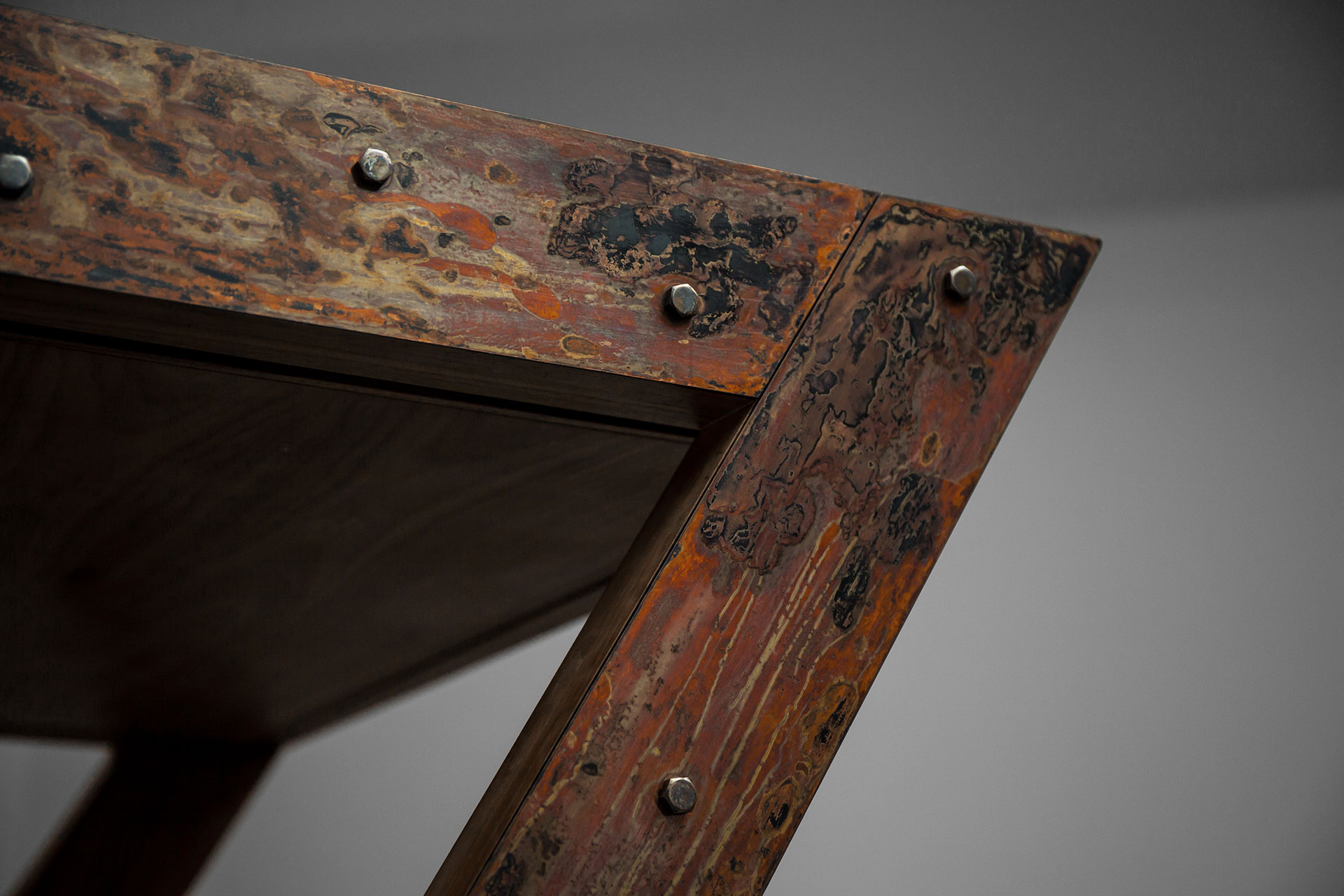 Aged copper finish with rust metal look on brutalist desk