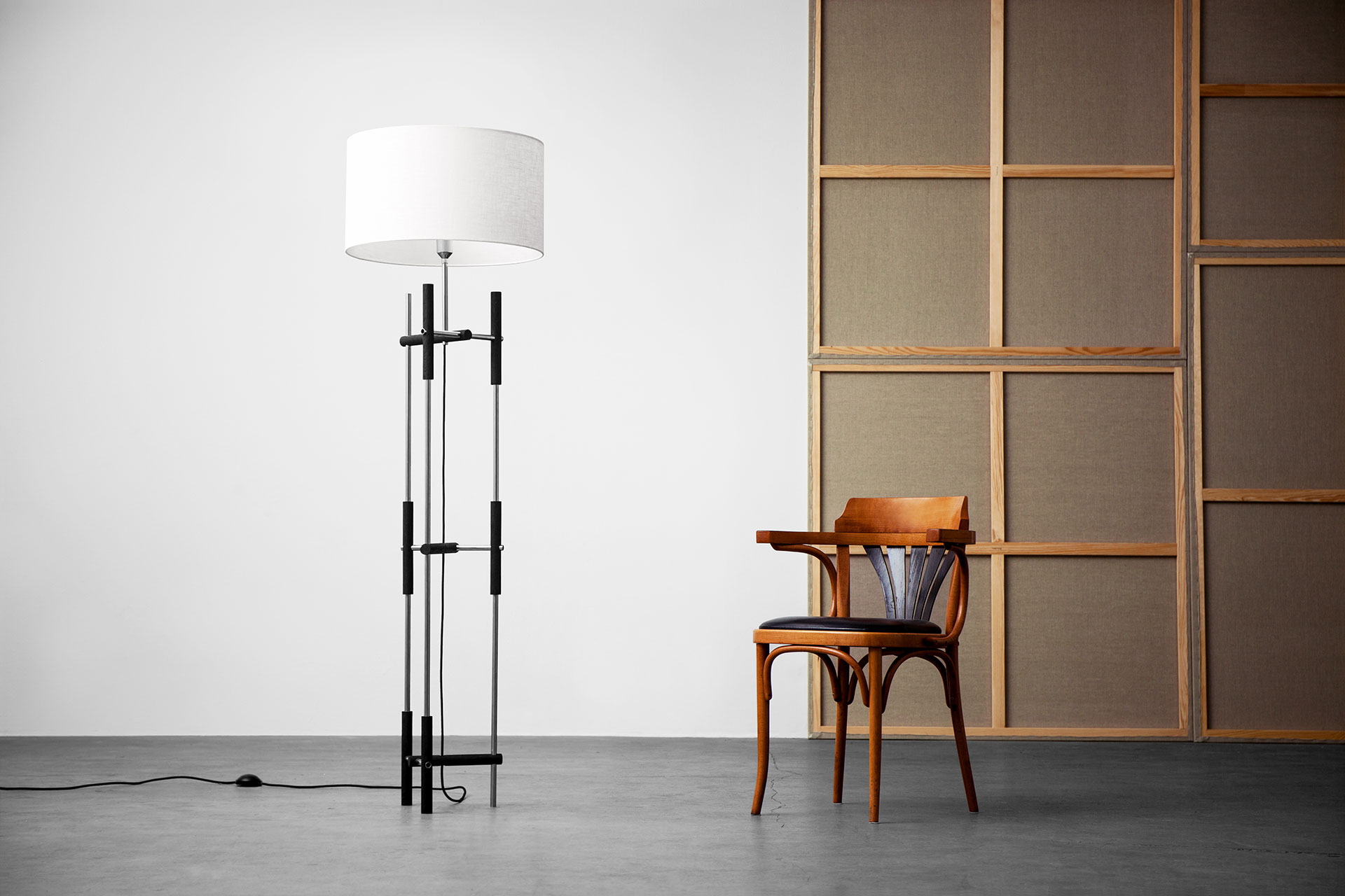 High-end design floor lamp in steel and bog oak with large linen shade in downtown loft apartment